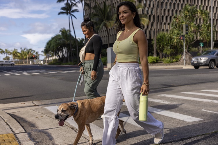 STANLEYのボトルを持って散歩をする女性